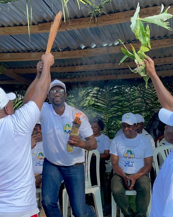 Community Bwiti ceremony with flame and palm fronds in Gabon