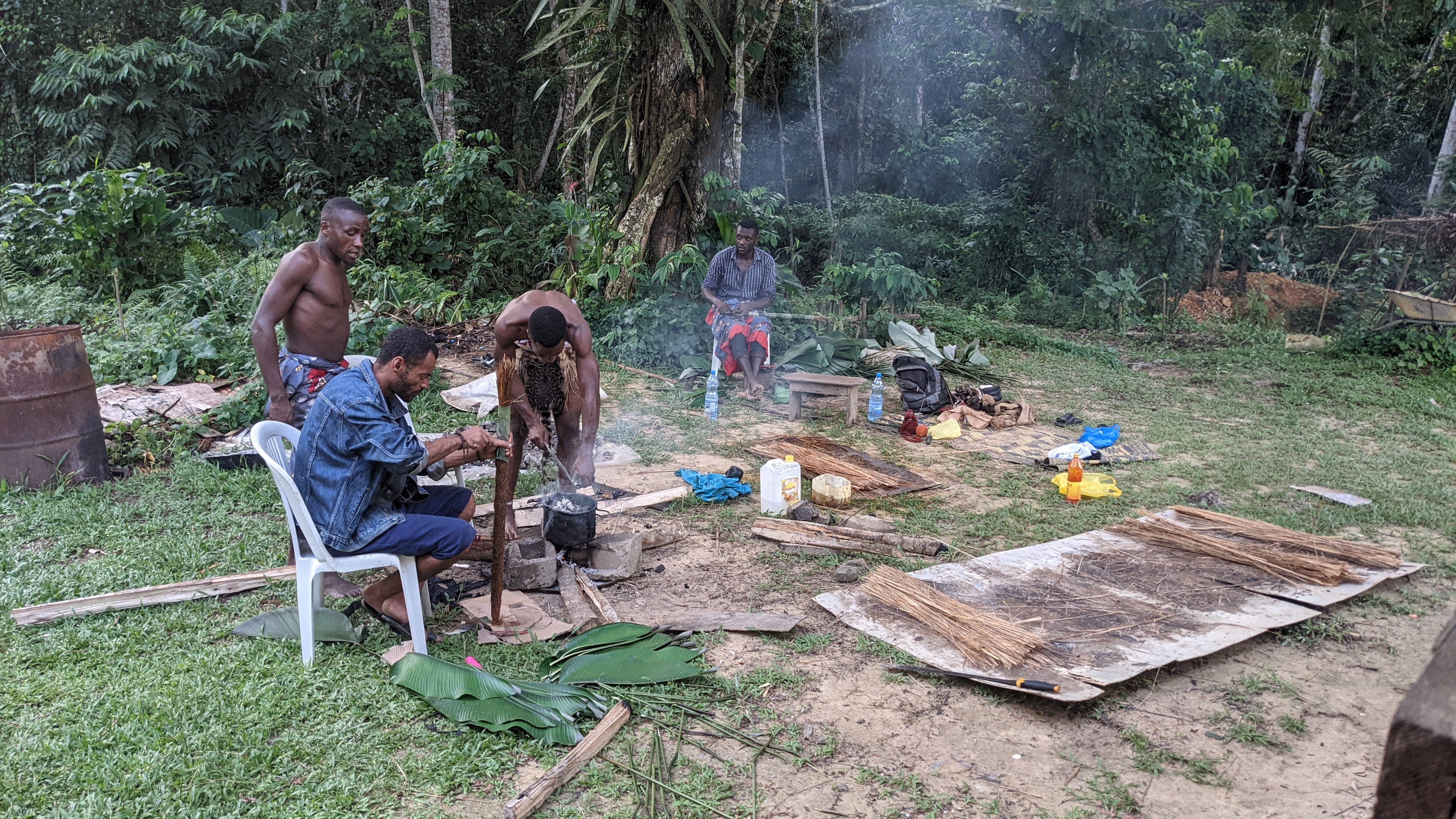 Bwiti practitioners preparing traditional medicine over a fire at a ceremony in Gabon